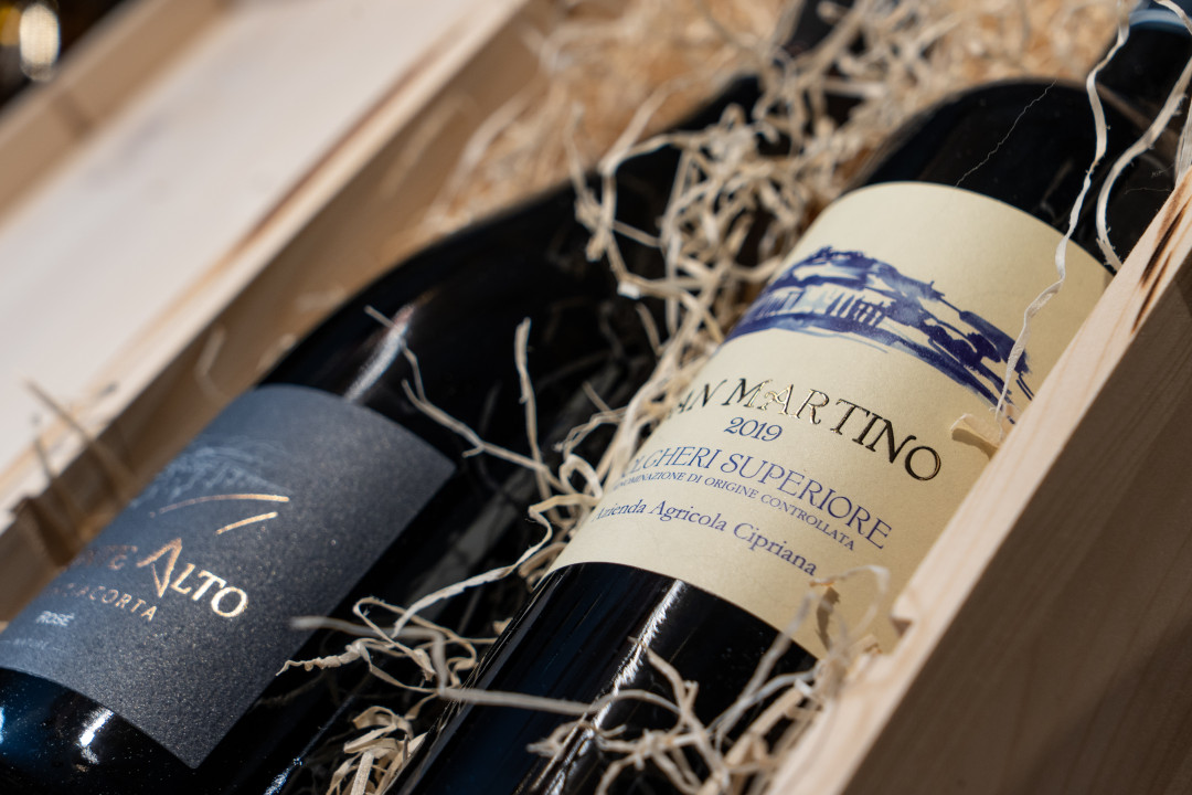 Dettaglio di bottiglie di vino di pregio dentro ad una confezione regalo in legno.